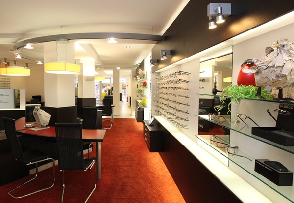 Modernes Optiker-Geschäft mit Brillenauswahl, Beratungstischen und stilvoller Einrichtung.